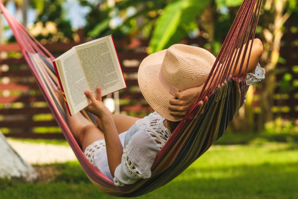 Frau liest ein Buch in einer Hängematte