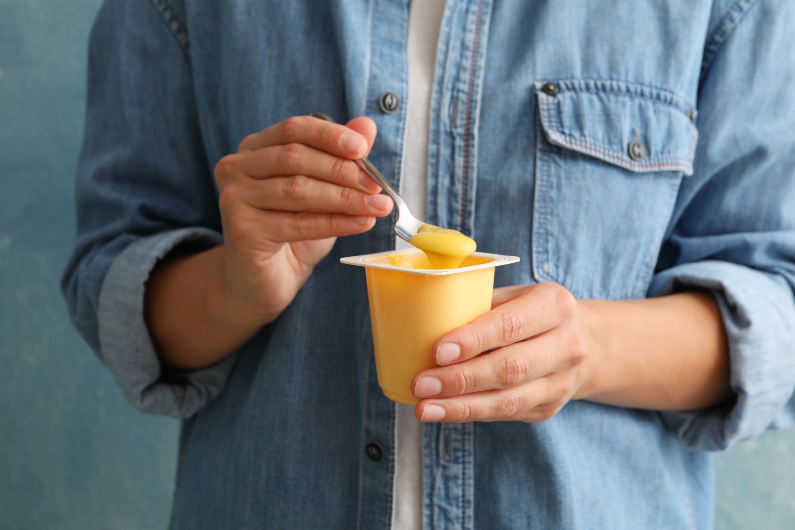 Frau isst Joghurt aus Joghurtbecher