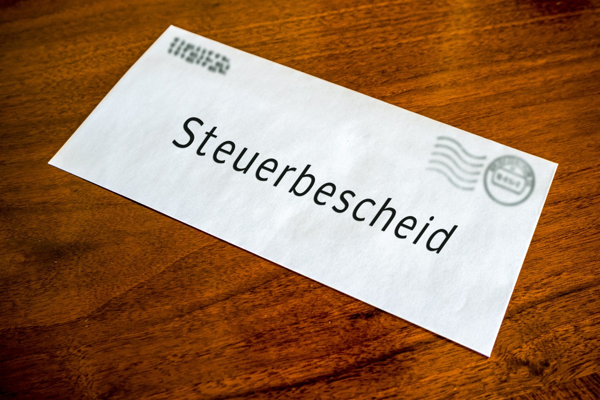 Ein Brief mit der Aufschrift "Steuerbescheid" liegt auf dem Tisch.