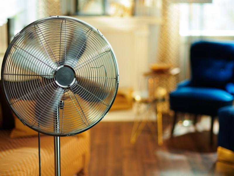 Ein Ventilator steht im Wohnzimmer.