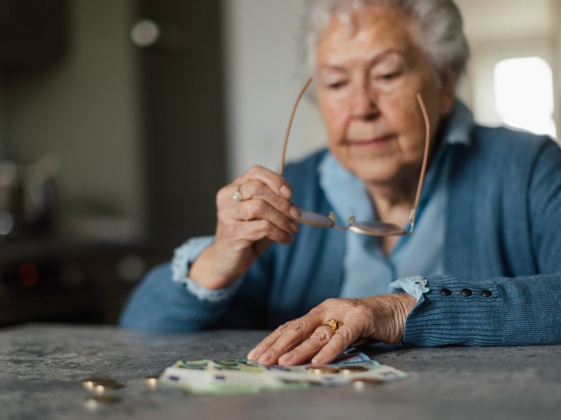 Seniorin schaut sich ihr Geld an.