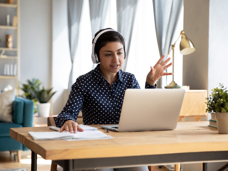 Eine Frau arbeitet im Homeoffice. Sie führt ein Meeting.