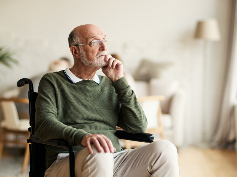 Ein Senior sitzt nachdenklich in seiner Wohnung.