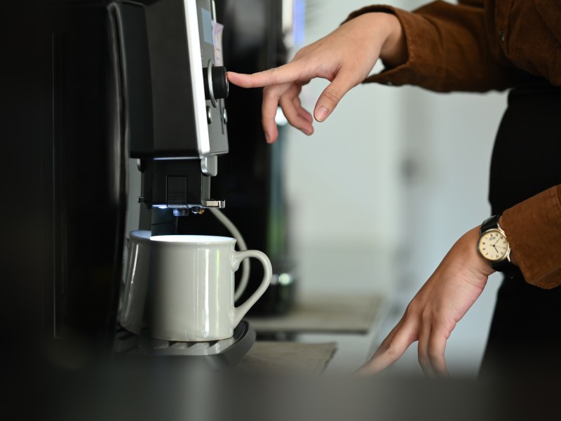 Frau an einer Kaffeemaschine