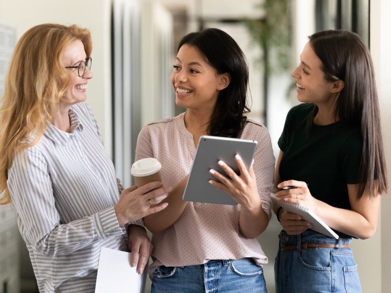 Drei Frauen reden im Büro.