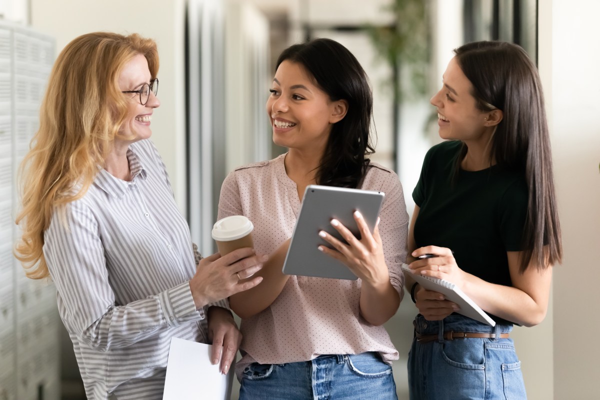 Drei Frauen reden im Büro.