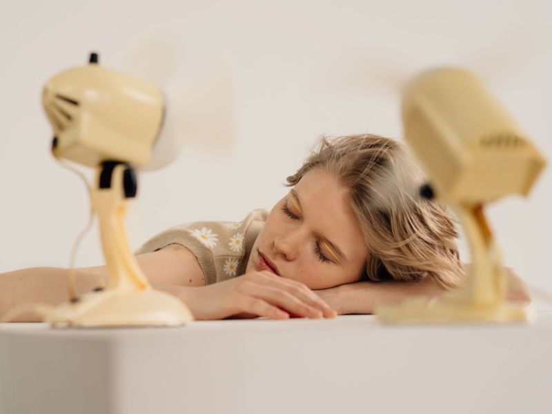 Frau schläft vor Ventilatoren