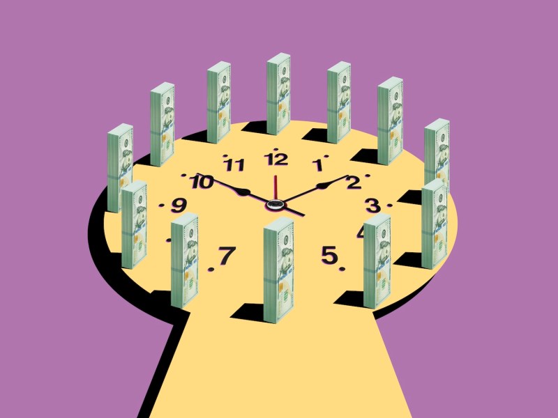 Zifferblatt auf einer gelben Oberfläche in Form eines Schlüssellochs, umgeben von Geldscheinen.