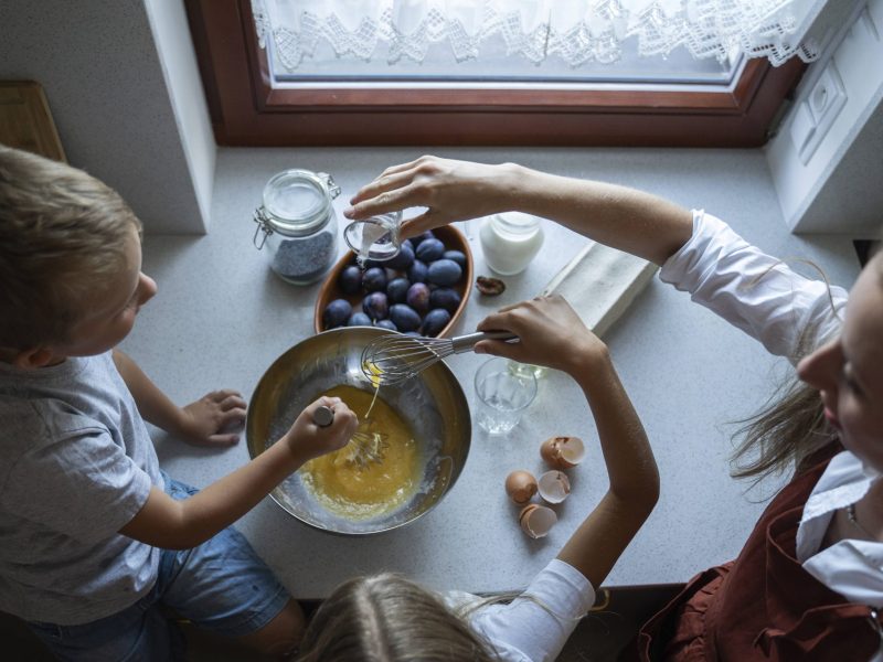 Eine Frau kocht mit ihrem Kind. Sie backen einen Kuchen.