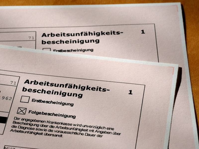 Zwei Arbeitsunfähigkeitsbescheinigungen liegen auf dem Tisch.