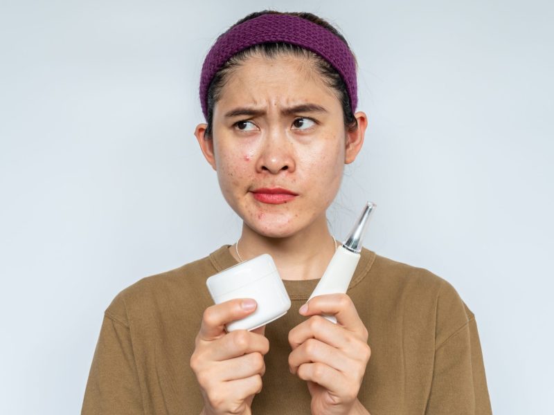 Eine Frau hält Hautpflege Produkte in der Hand.