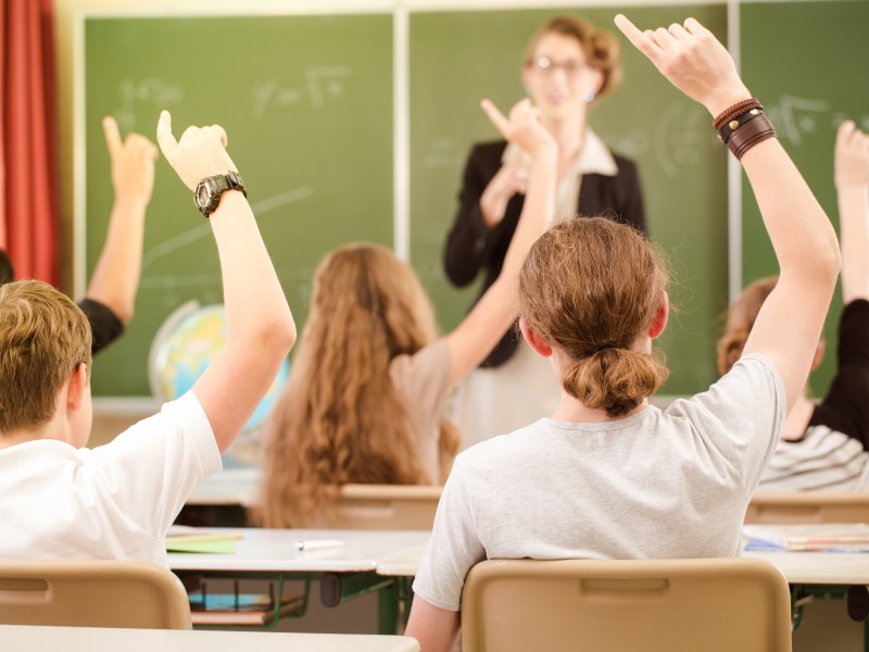 Jugendliche sitzen im Klassenzimmer und melden sich.