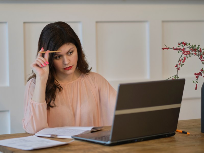 Frau am Laptop: Reisen und Blogging sind ideale Hobbys und coole Side Hustles für das Sternzeichen Schütze