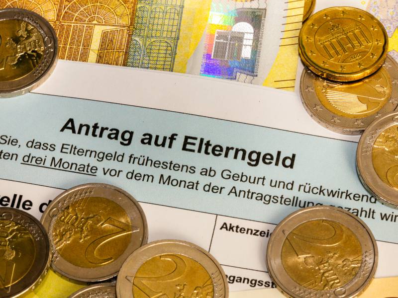 Ein Antrag auf Elterngeld liegt zwischen GeldmÃ¼nzen