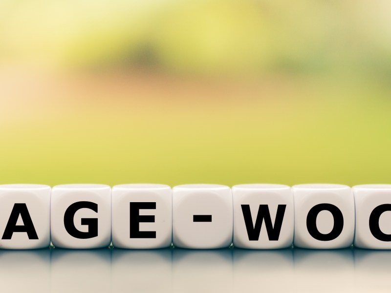 Mit weißen Würfeln wurde das Wort Vier-Tage-Woche geschrieben