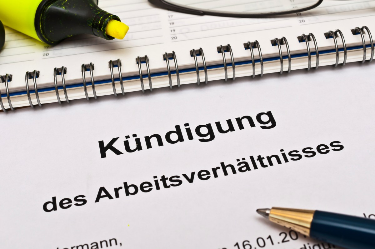 Auf einem Blattpapier steht die Aufschrift "Kündigung des Arbeitsverhältnisses". Daneben liegt ein Kugelschreibe.