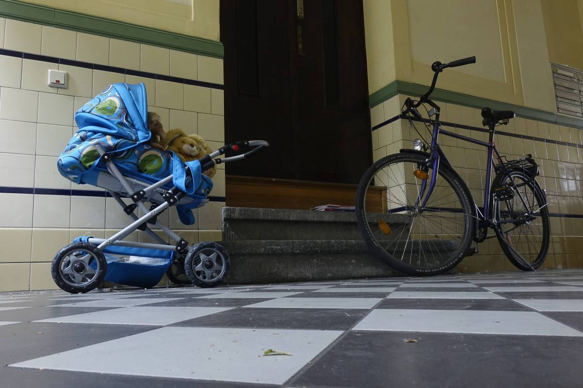 Ein Fahrrad und ein Kinderwagen stehen im Hausflur.