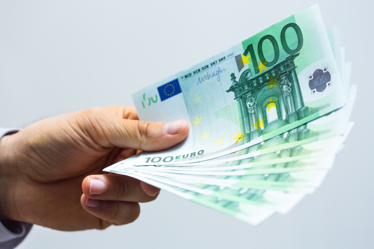 Eine Person hÃ¤lt mehrere 100-Euro-Scheine in der Hand.