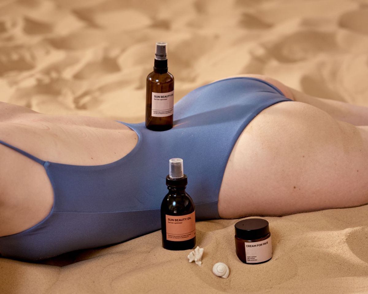 Frau im Bikini mit Sonnenschutz-Produkten