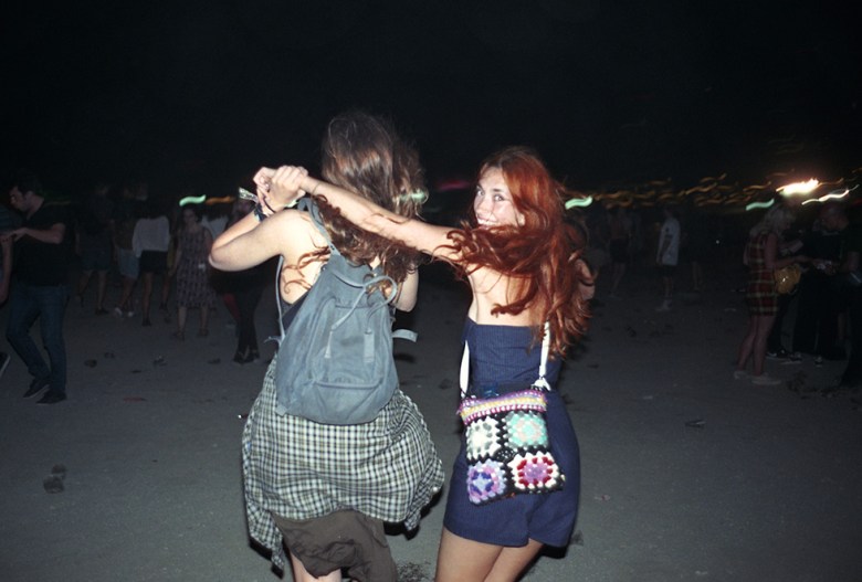 Zwei Frauen die lachend über ein Festival Gelände laufen