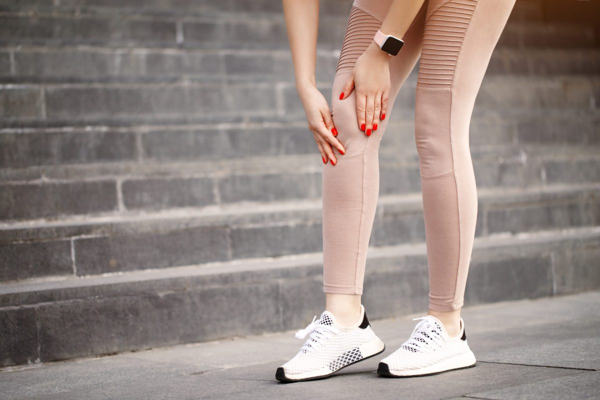 Frau hat Knieschmerzen beim Joggen