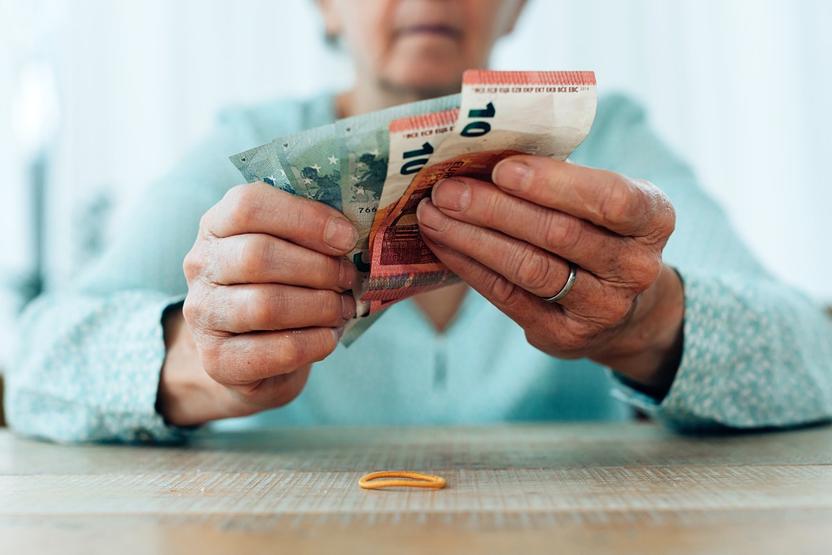 Eine Seniorin hält Geldscheine in der Hand.