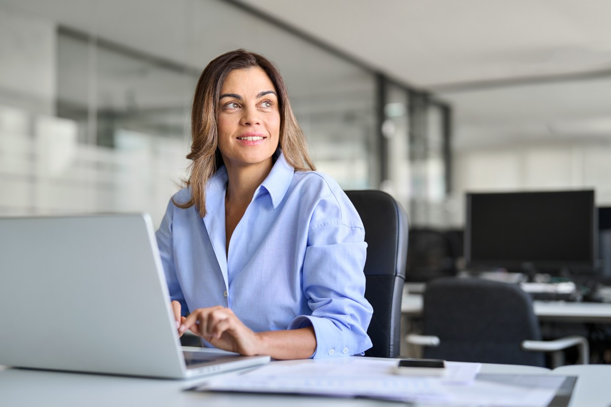 Eine Frau sitzt im Büro an ihrem Laptop.