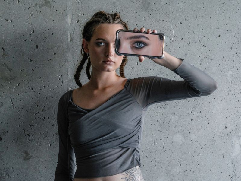 Frau hält sich ein Handy vor das Gesicht