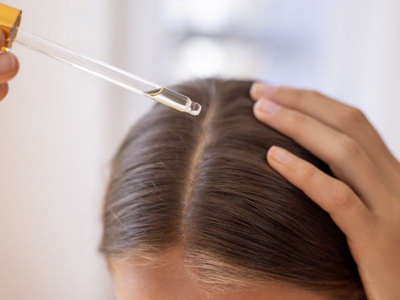 Frau trägt Haaröl auf.