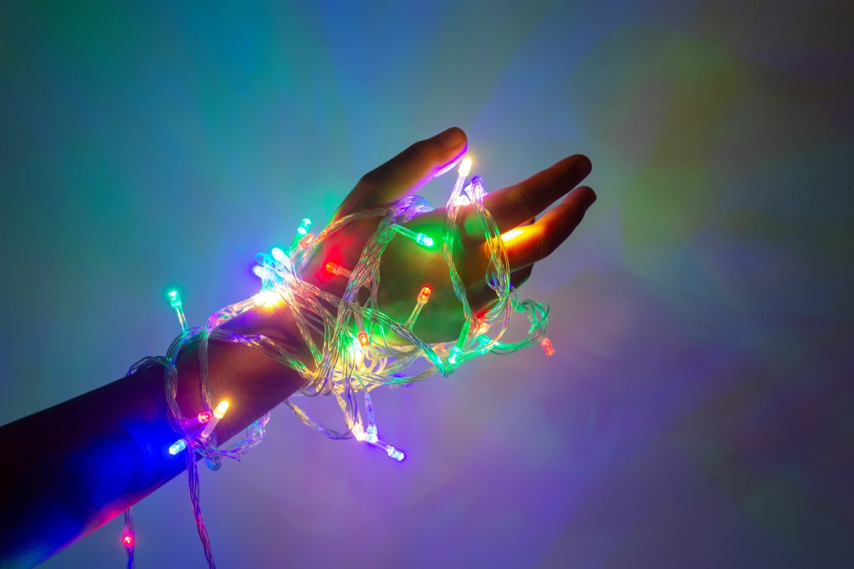 Hand umwickelt mit bunter Lichterkette