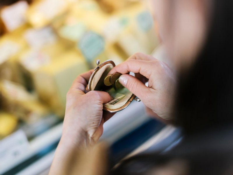 Nahaufnahme einer Frau, die am Marktstand bezahlt. Sie hÃ¤lt eine GeldbÃ¶rse in der Hand.