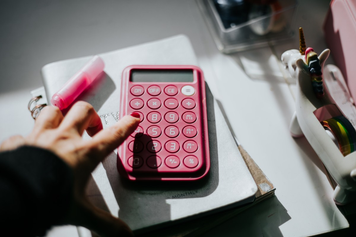 Weißer Taschenrechner und Bleistift sowie einige Clips in Weiß.