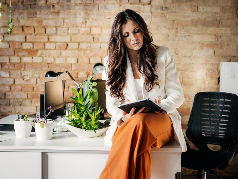 Eine Frau sitzt im Büro und schaut sich Dokumente an.