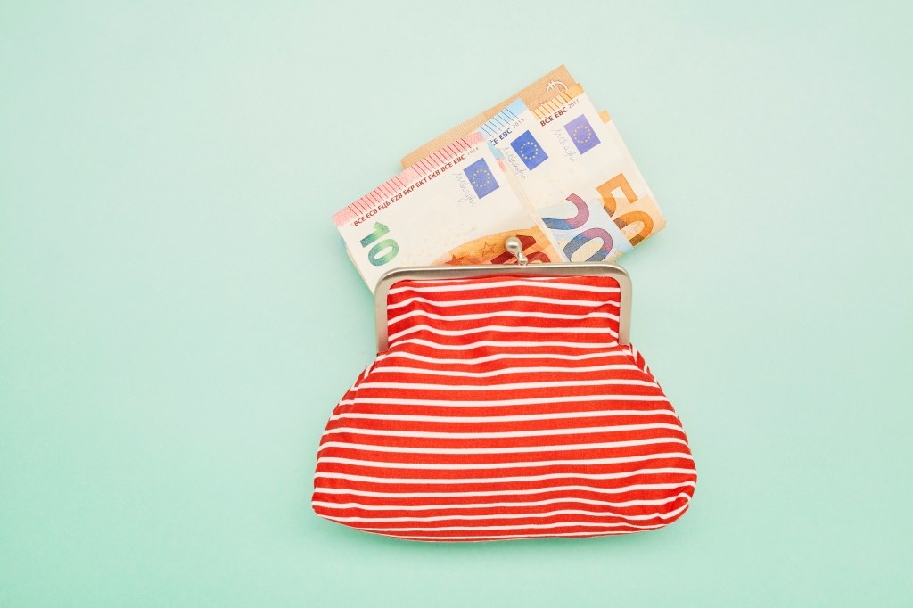 Brieftasche und Euro-Banknoten auf t&uuml;rkisfarbenem Hintergrund