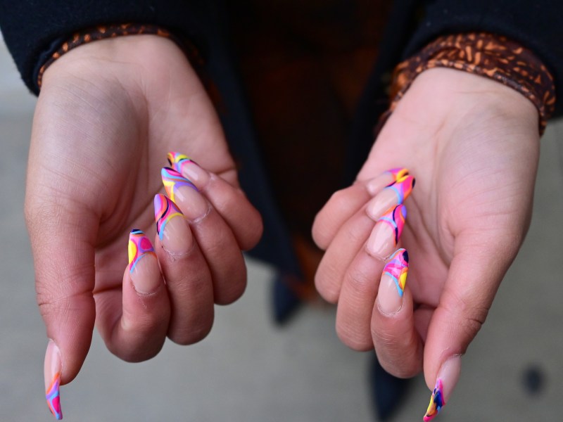 Frau zeigt ihre Stiletto-Nägel