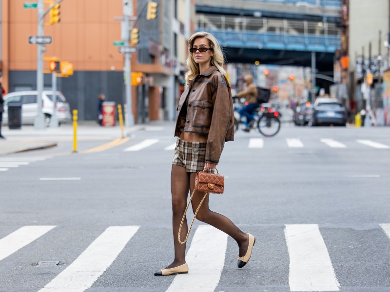 Frau geht in Outfit über Straße