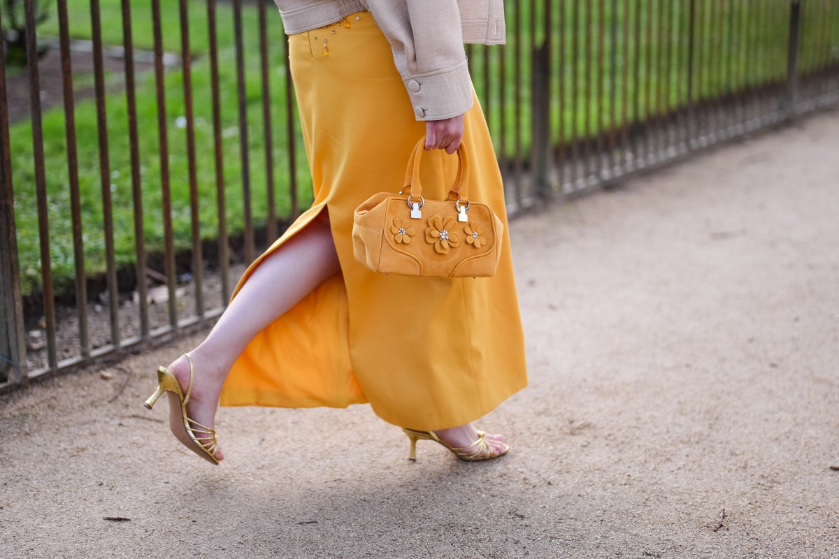 Frau trägt gelben Rock und Tasche