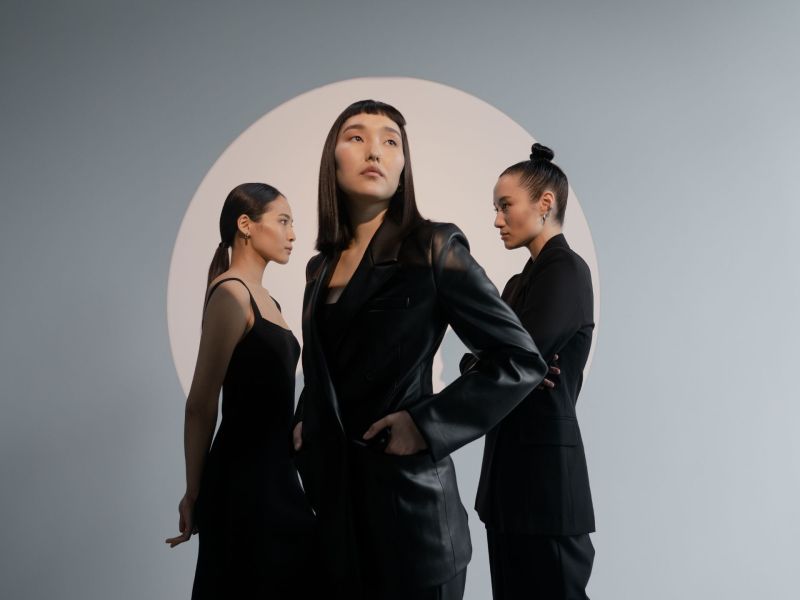 Drei Frauen stehen sich gegenüber.