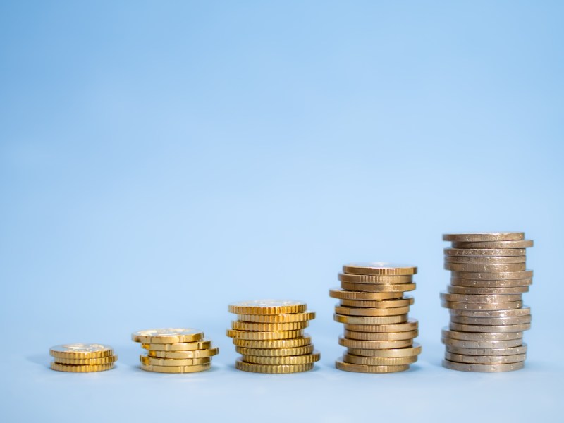 Mehre Münzstapel auf blauen Hintergrund.