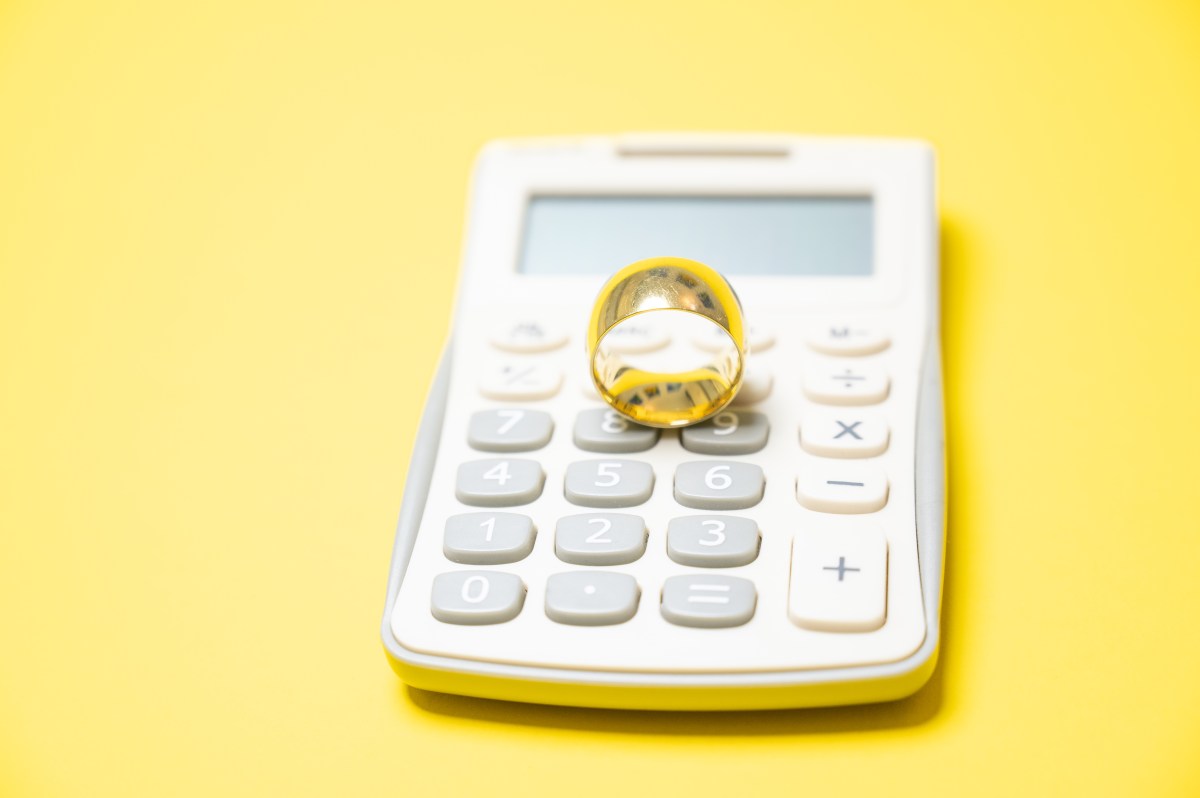 Ein Taschenrechner und Hochzeitsring.