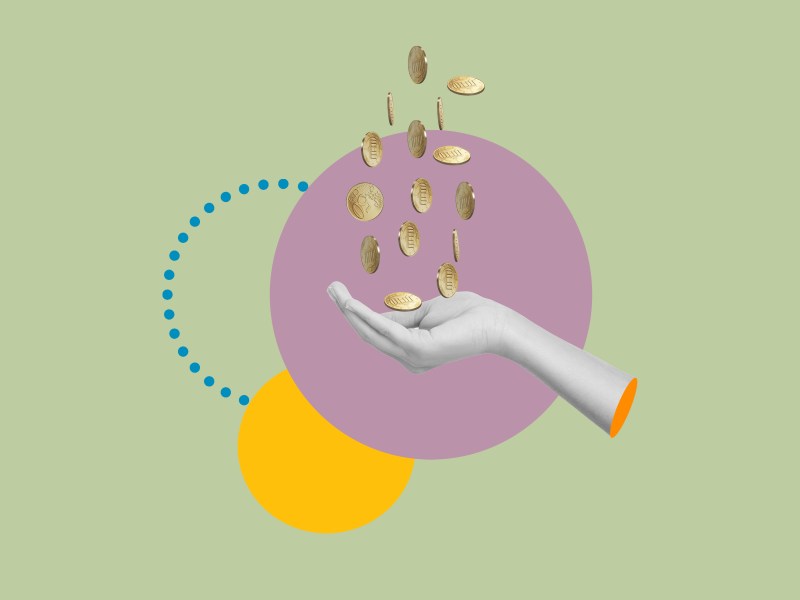 In eine Hand fallen Münzen.