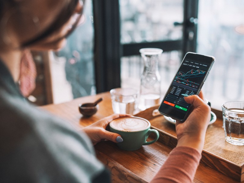 Frau kauft mit Smartphone Kryptowährung.