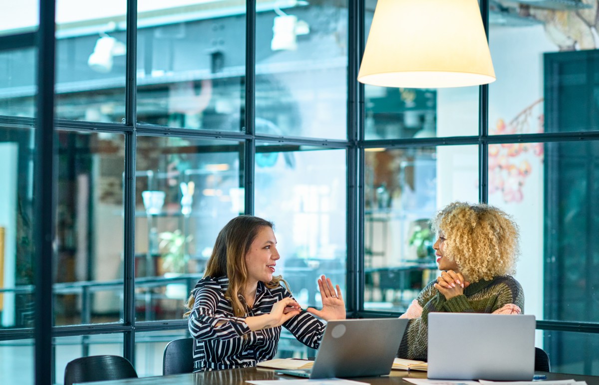 Zwei Frauen führen ein Gehaltsgespräch Gespräch in einem modernen Büro.