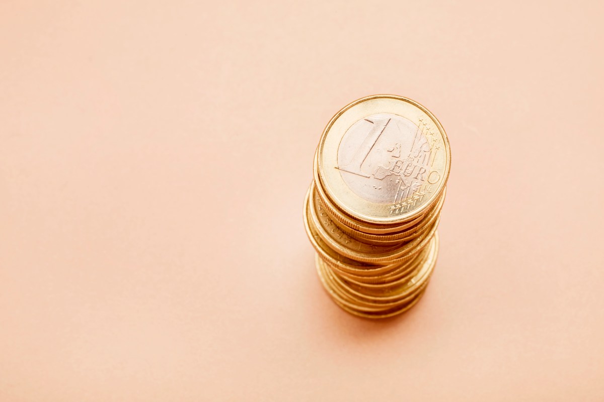Stapel von Ein-Euro-Münzen auf beigen Hintergrund.