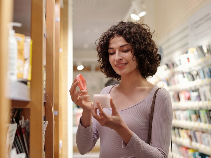 Frau bei Rossmann hält Primer in der Hand