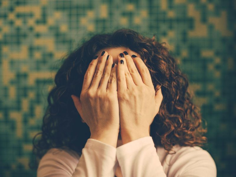 Frau versteckt Gesicht in den Händen
