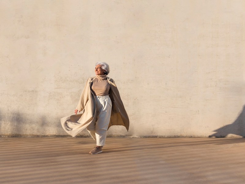 Eine Seniorin vor beigen Hintergrund.