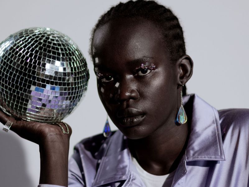 Frau mit Discokugel in der Hand