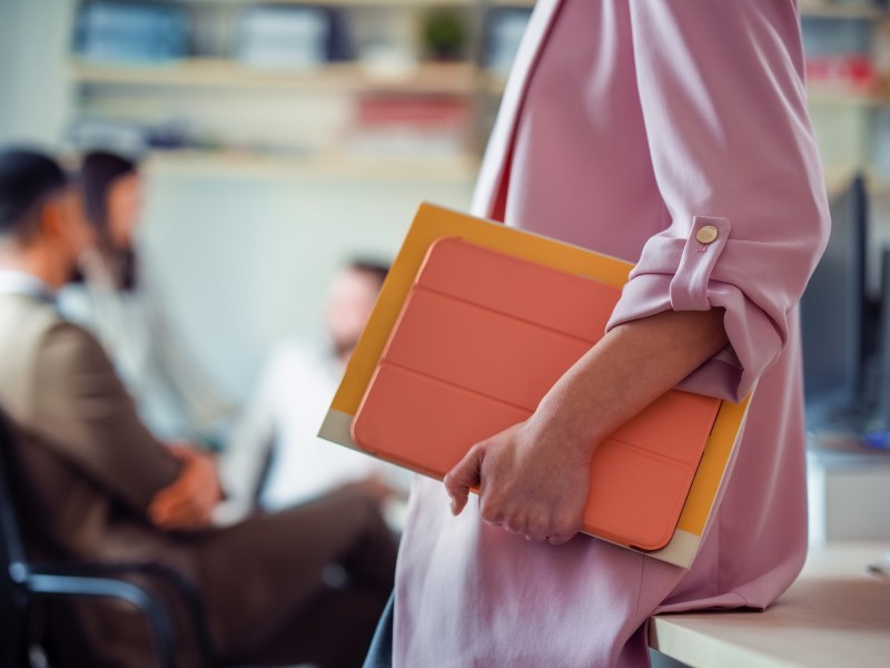 Nahaufnahme einer berufstätigen Frau, die Akten hält.