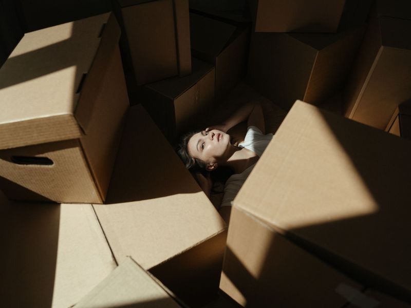 Frau liegt inmitten von Boxen